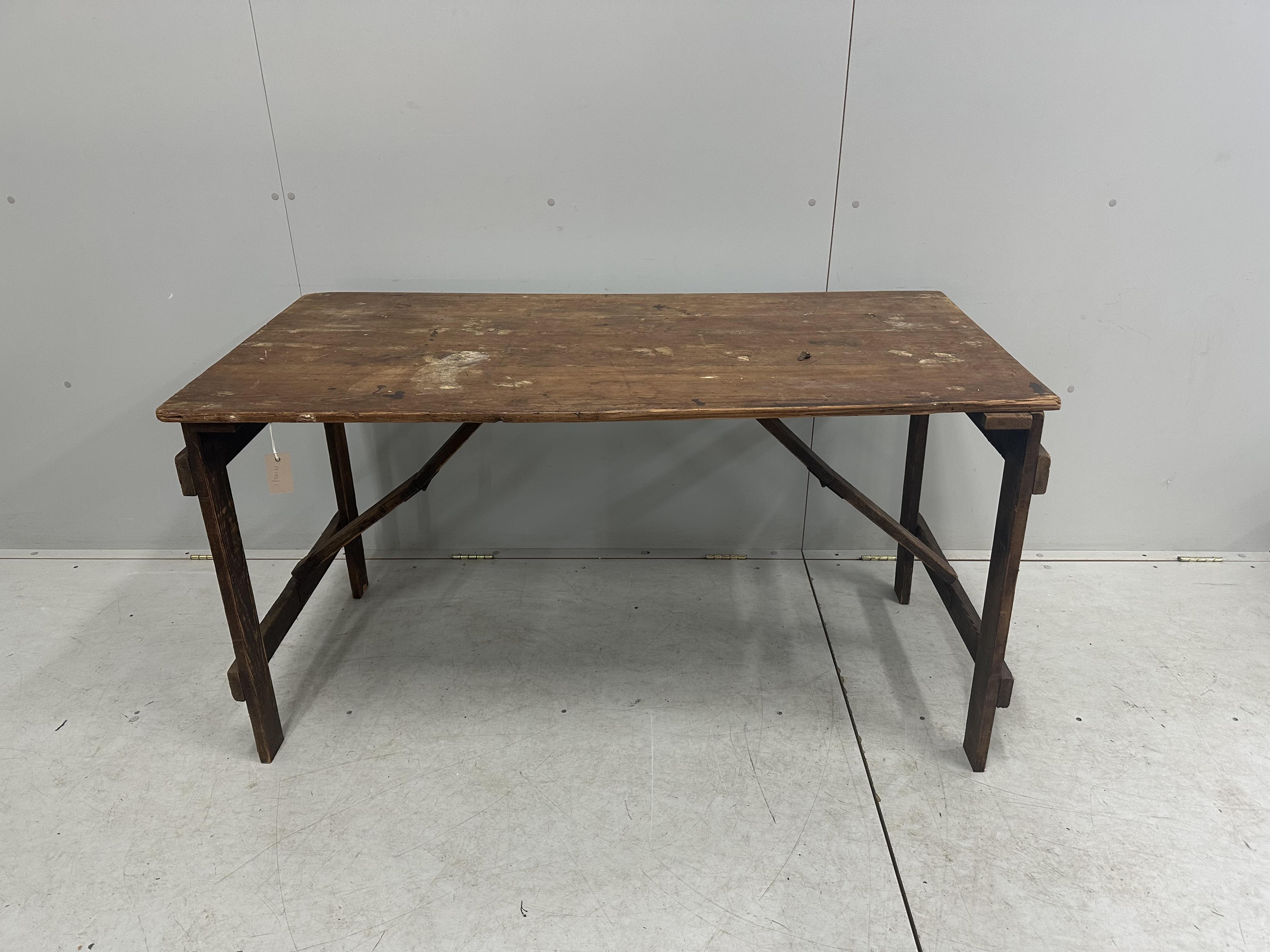 A folding pine trestle table, width 136cm, depth 67cm, height 74cm. Condition - poor